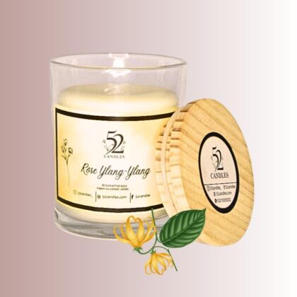 Rose ylang-ylang scented candle in glass jar with wooden lid.